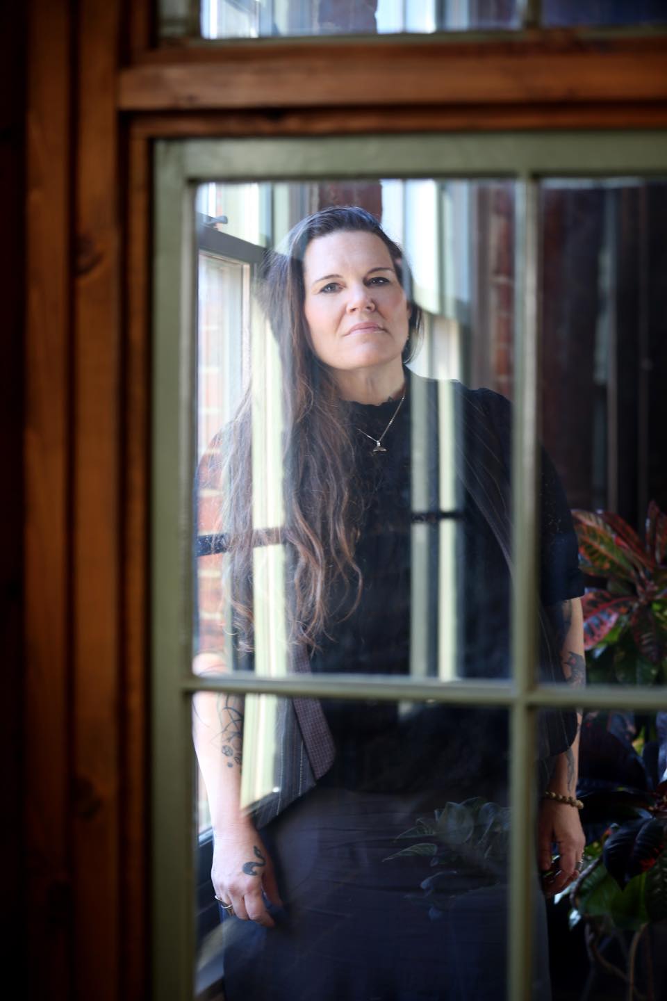 Portrait of Allison as seen through a window frame in an office